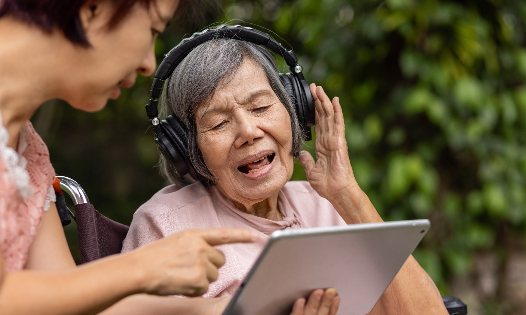 MND Queensland Carer Program image of a lady using AAC receiving care from a care giver